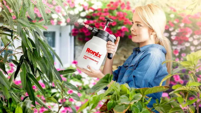 A woman using one of the best garden sprayers from Ronix collection to water plants