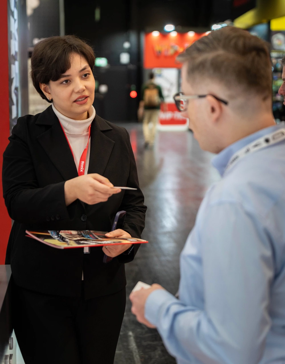 Mina, Ronix sales expert presenting Ronix catalog to a visitor at IEM2024