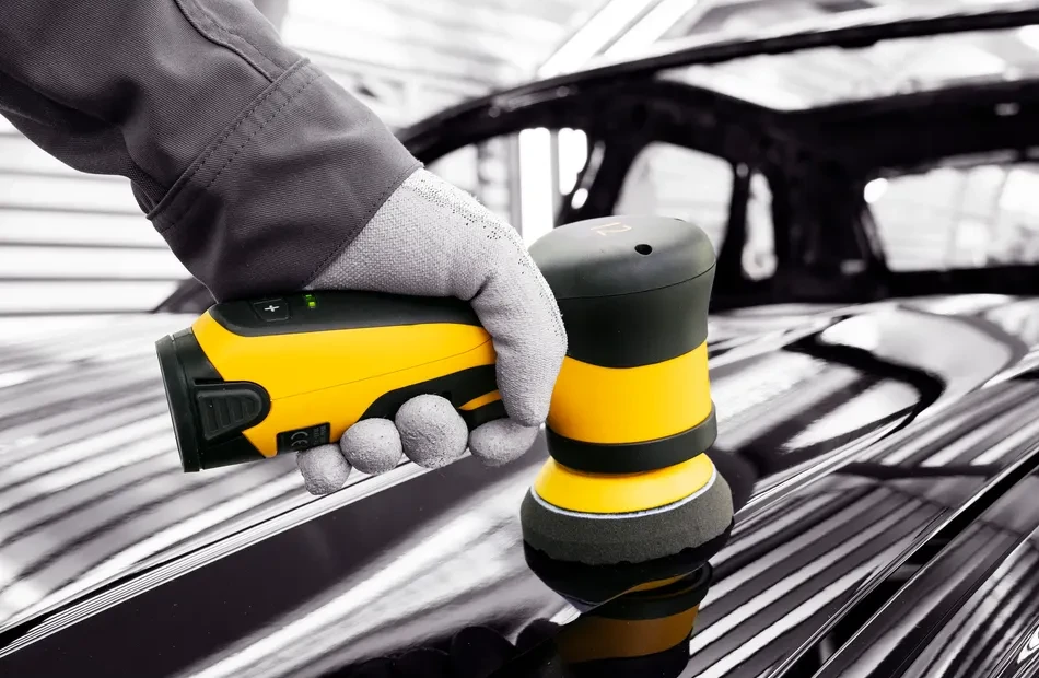 hand of an operator using a 3-inches orbital polisher on a car