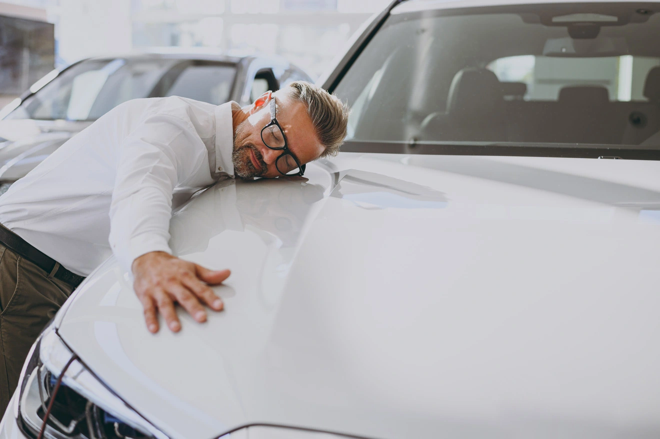 a man is leaning on a car with arms wide open and showing admiration