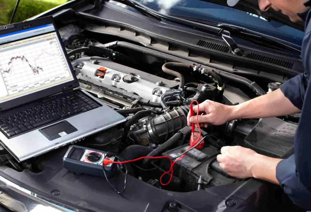 mechanic using diagnostics tools on a car