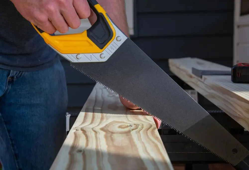 hand saw being used to cut lumber