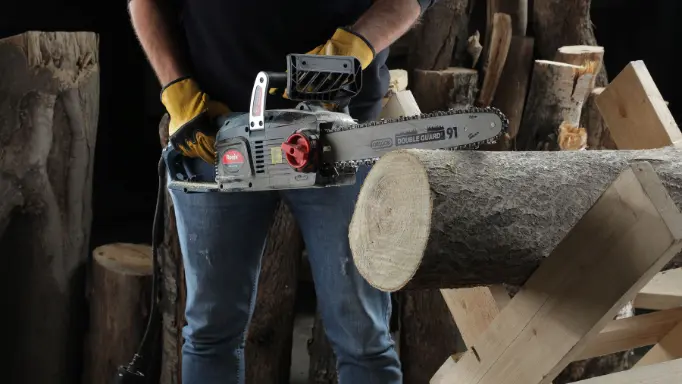 A lumberjack cutting a log with a Ronix chainsaw
