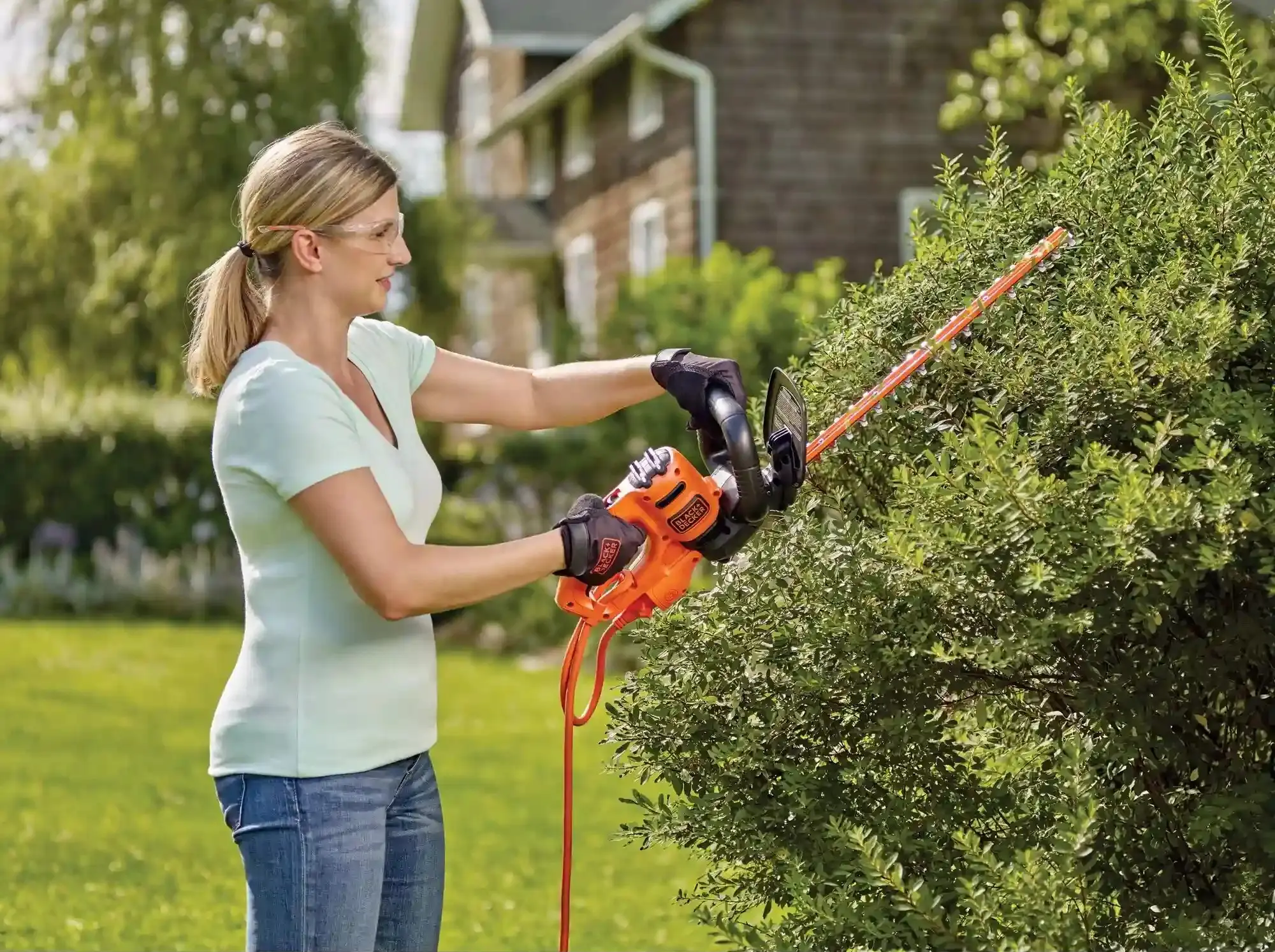 picture of a person using a black and decker hedge trimmer