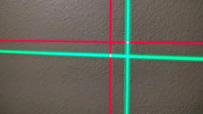 red and green laser levels’ projected beams on the wall