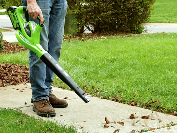 a man using an air blower to blow leaves 