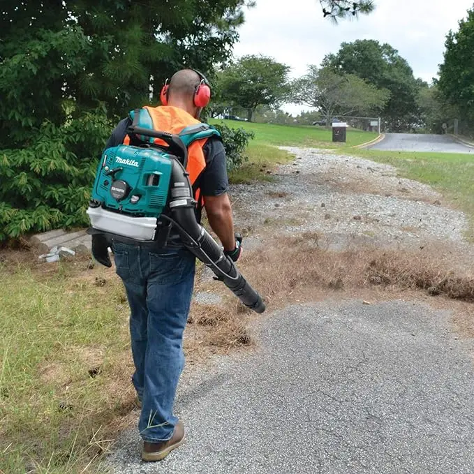 a man carrying a backpack blower