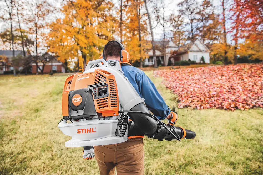 A man going to blow leaves with an air leaf blower