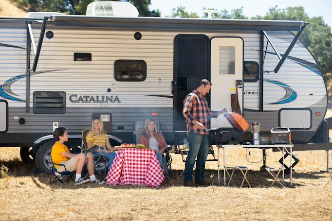 Family enjoying a picnic next to their RV