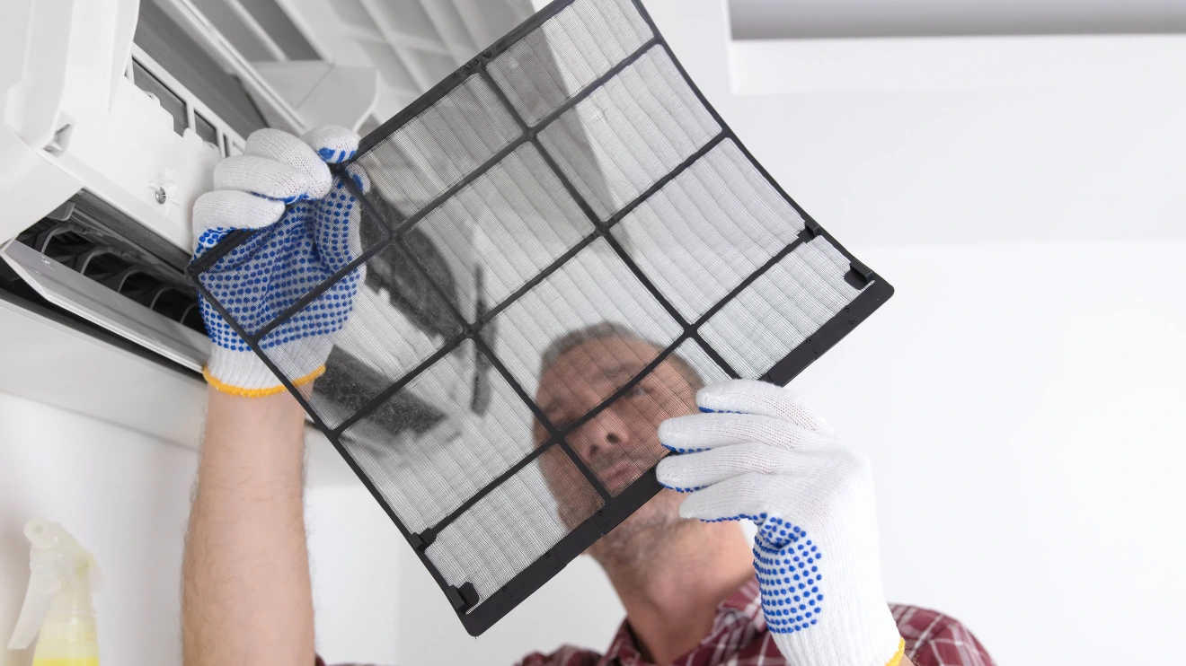 A man checking an AC filter