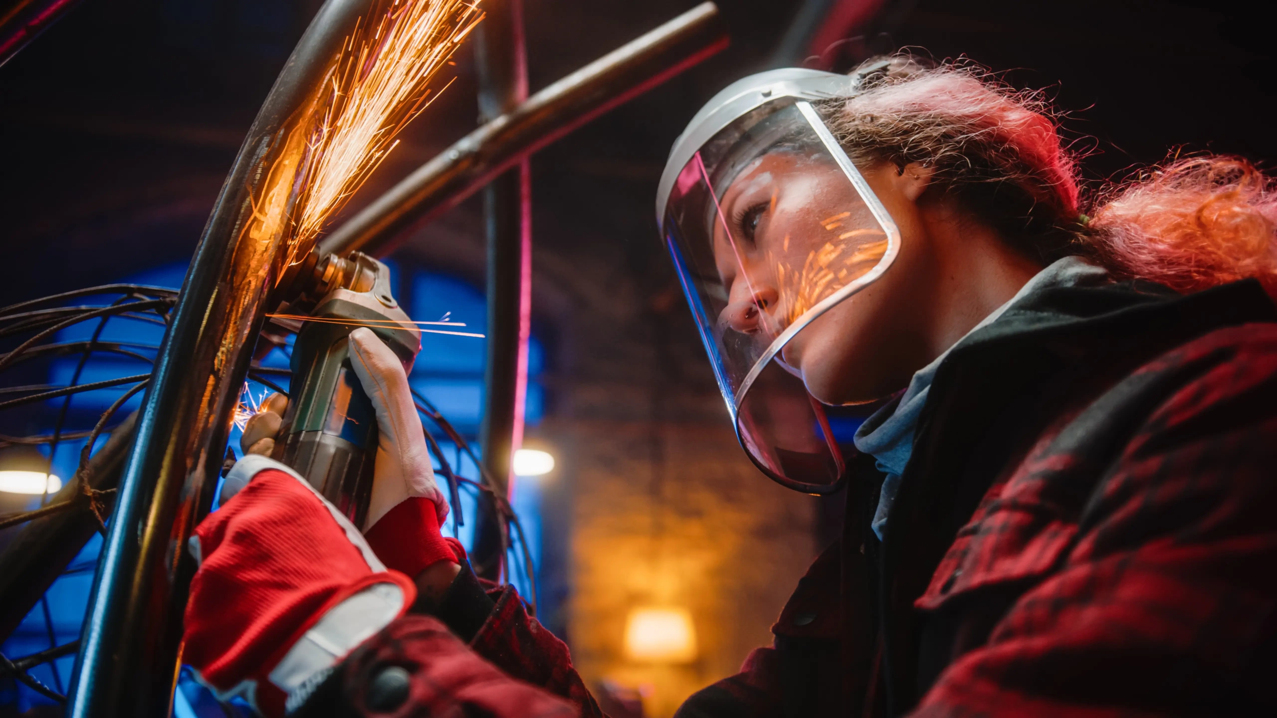 A woman working with an angle grinder for metal