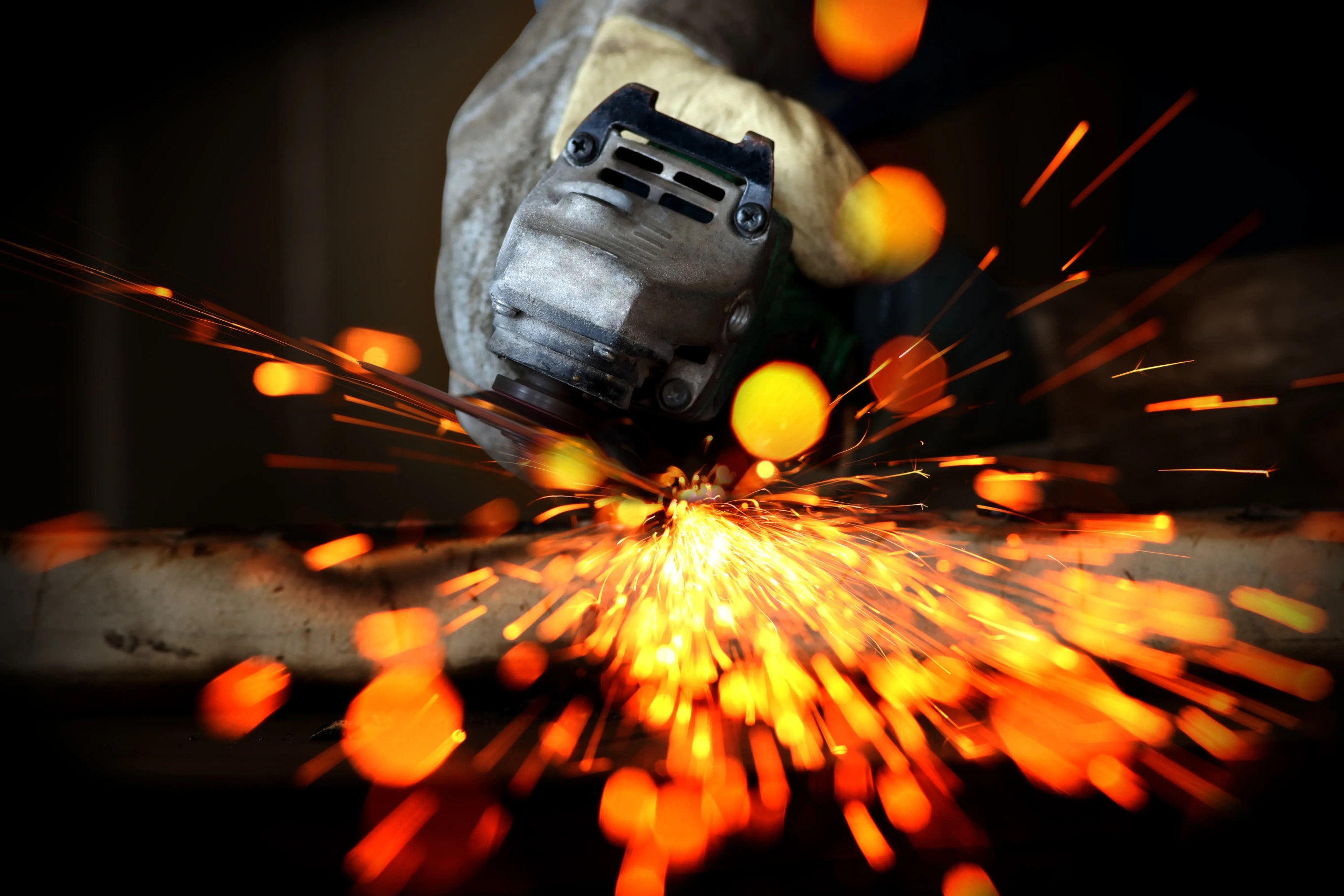 An Angle Grinder working with sparks in flying out of it 