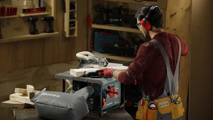 A tabletop type of table saw is being used to cut wood