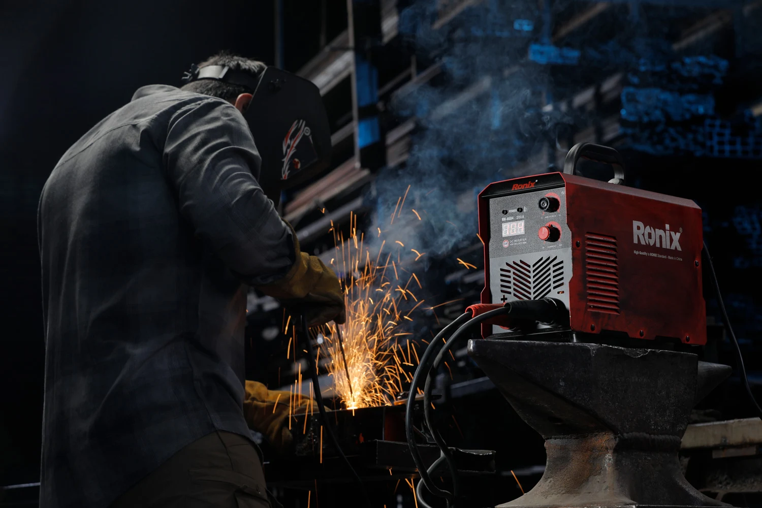 An operator is welding metal with the Ronix RH-4604 welding machine