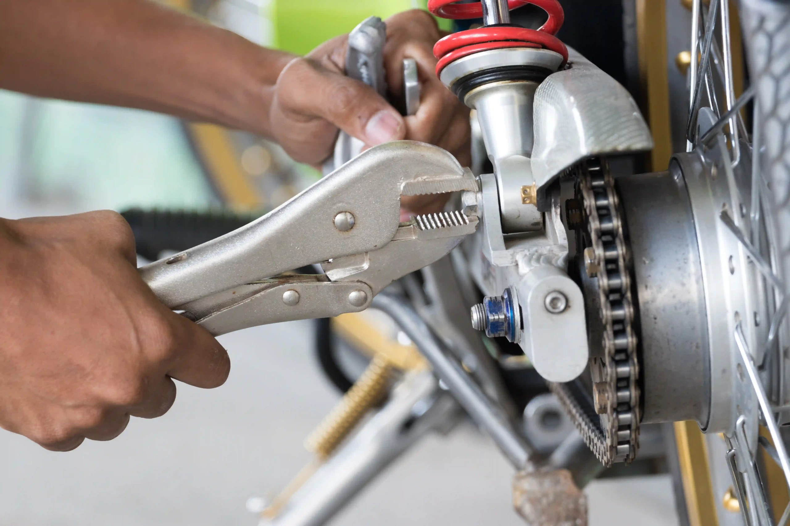 Locking pliers adjusting a motorcycle's chain mechanism