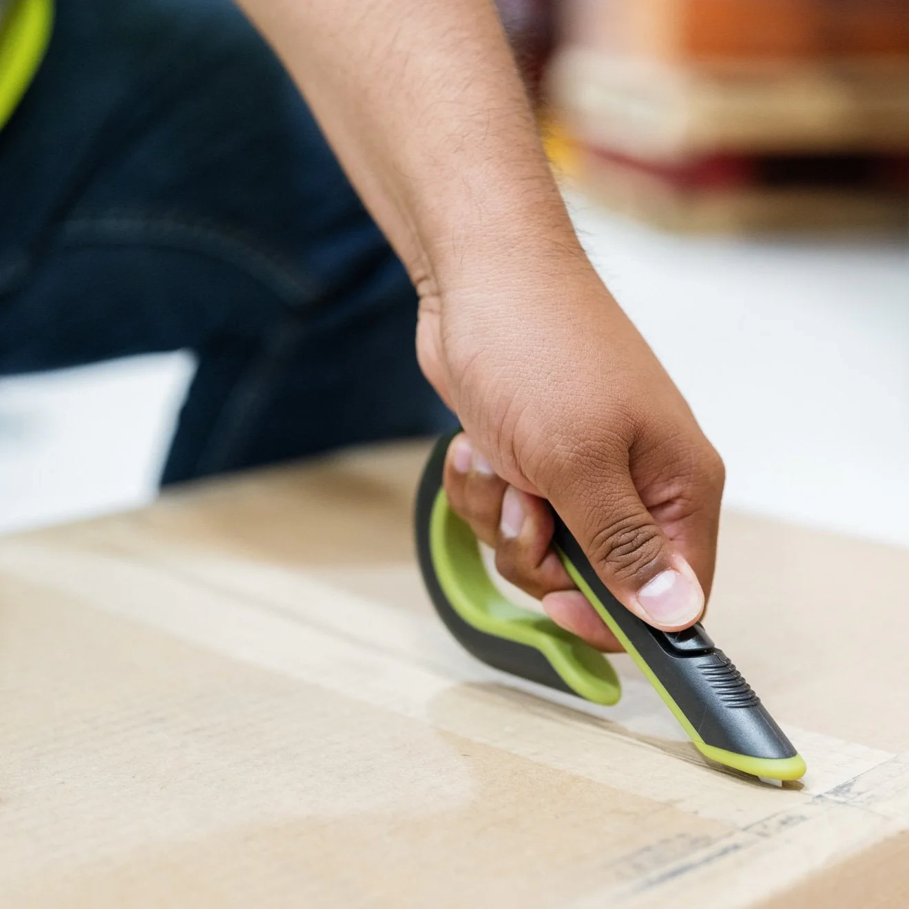 picture of a person using a slice box cutter in a warehouse