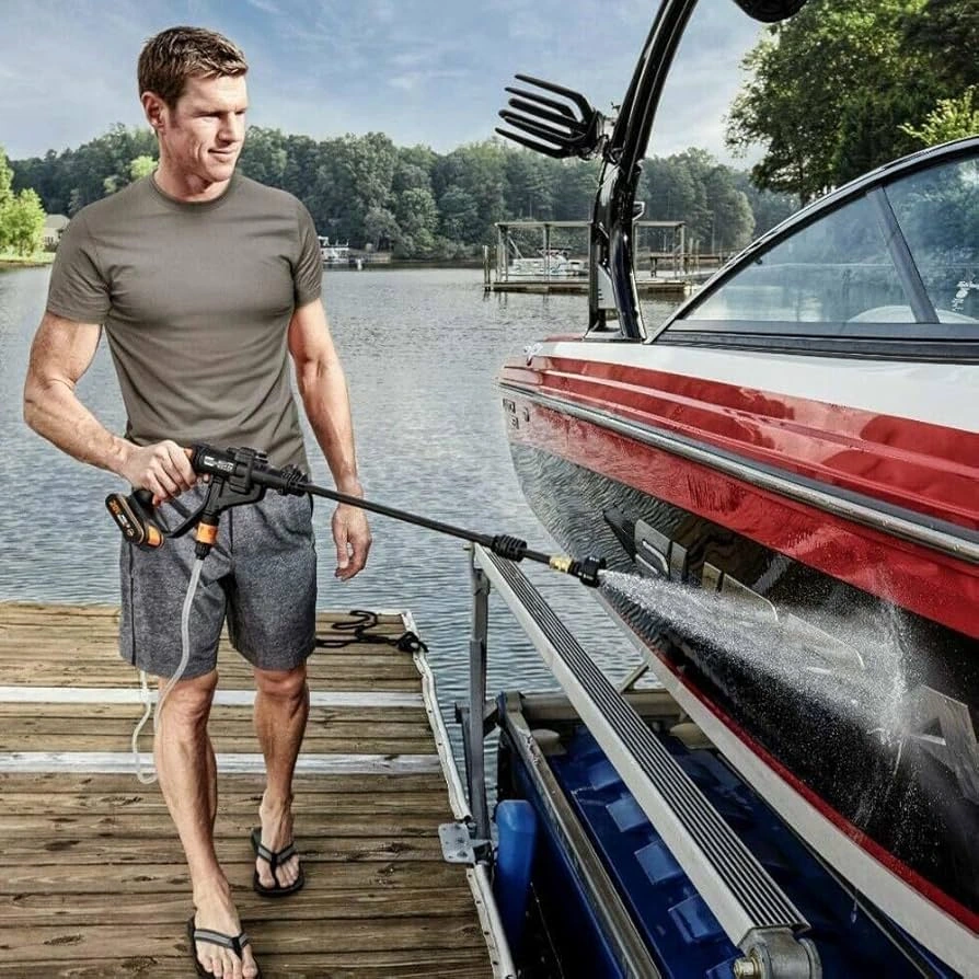 picture of a man using a cordless pressure washer for a boat