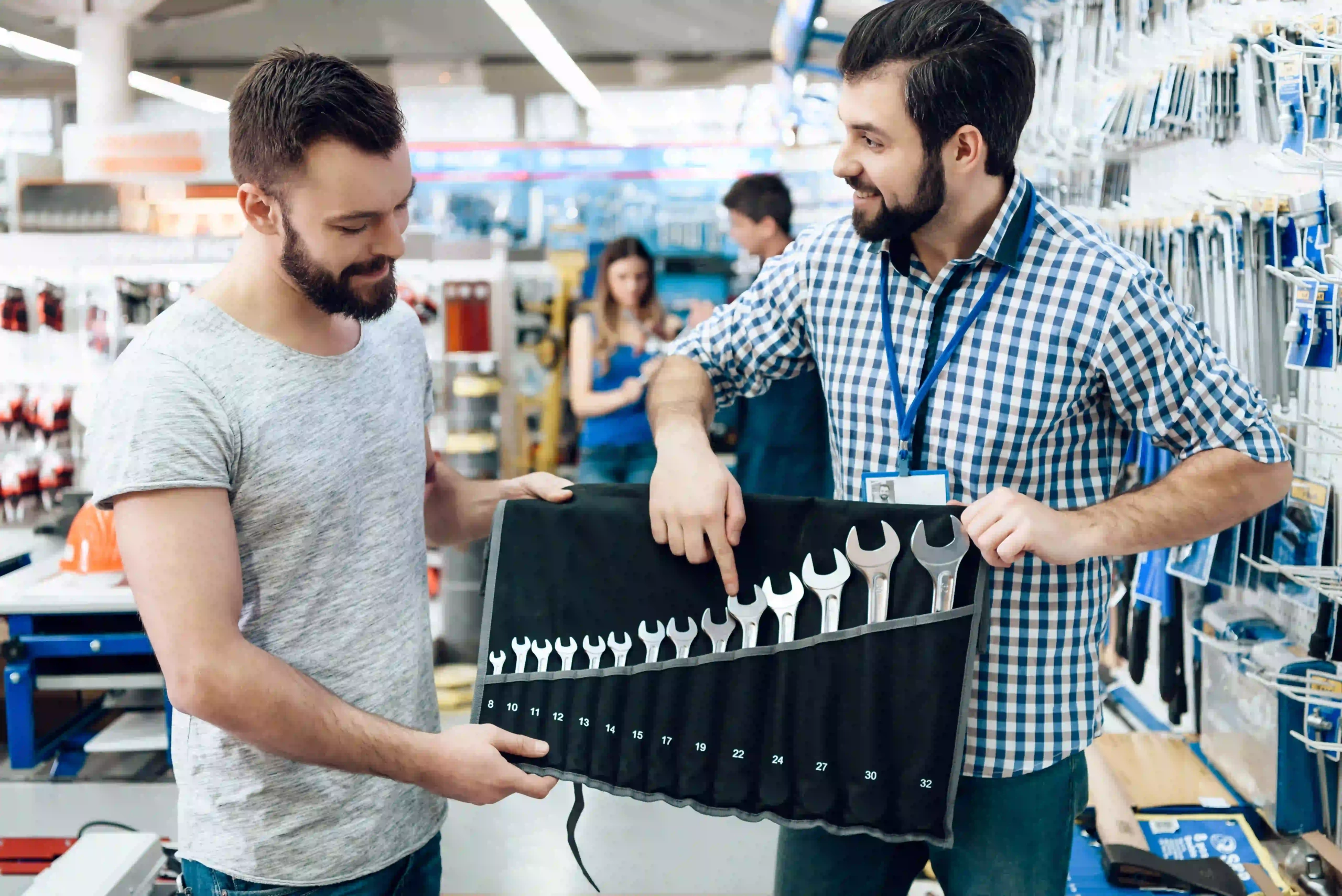 Customer and store associate discussing the best spanner set in a hardware store