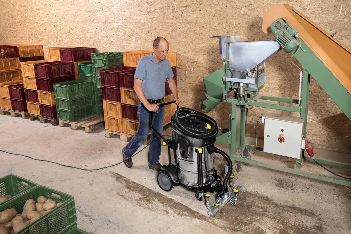  A an is working with an industrial vacuum cleaner in a winery factory