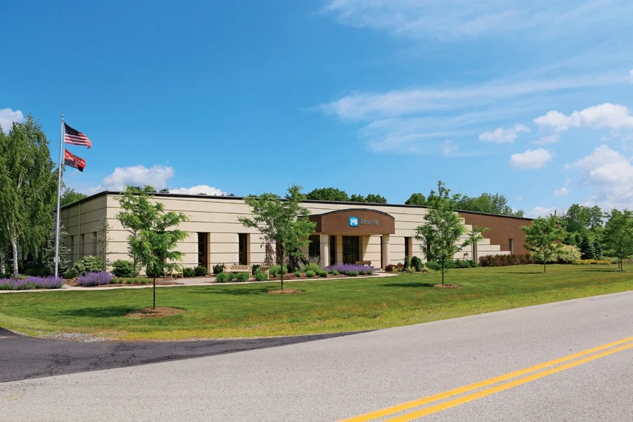 New Pig Corporation office building with flags and landscaped lawn