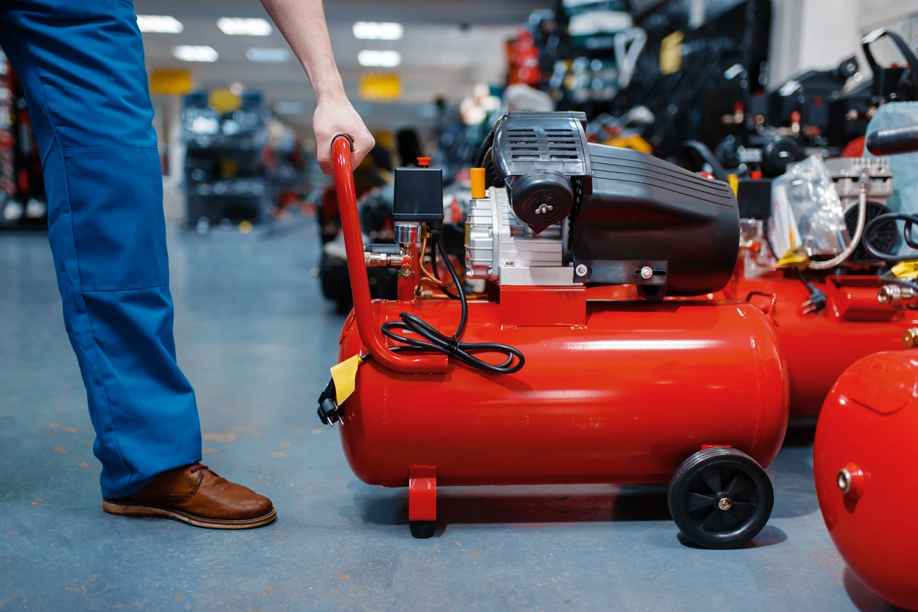 A photo of a man’s hand taking an air compressor’s handle to move it