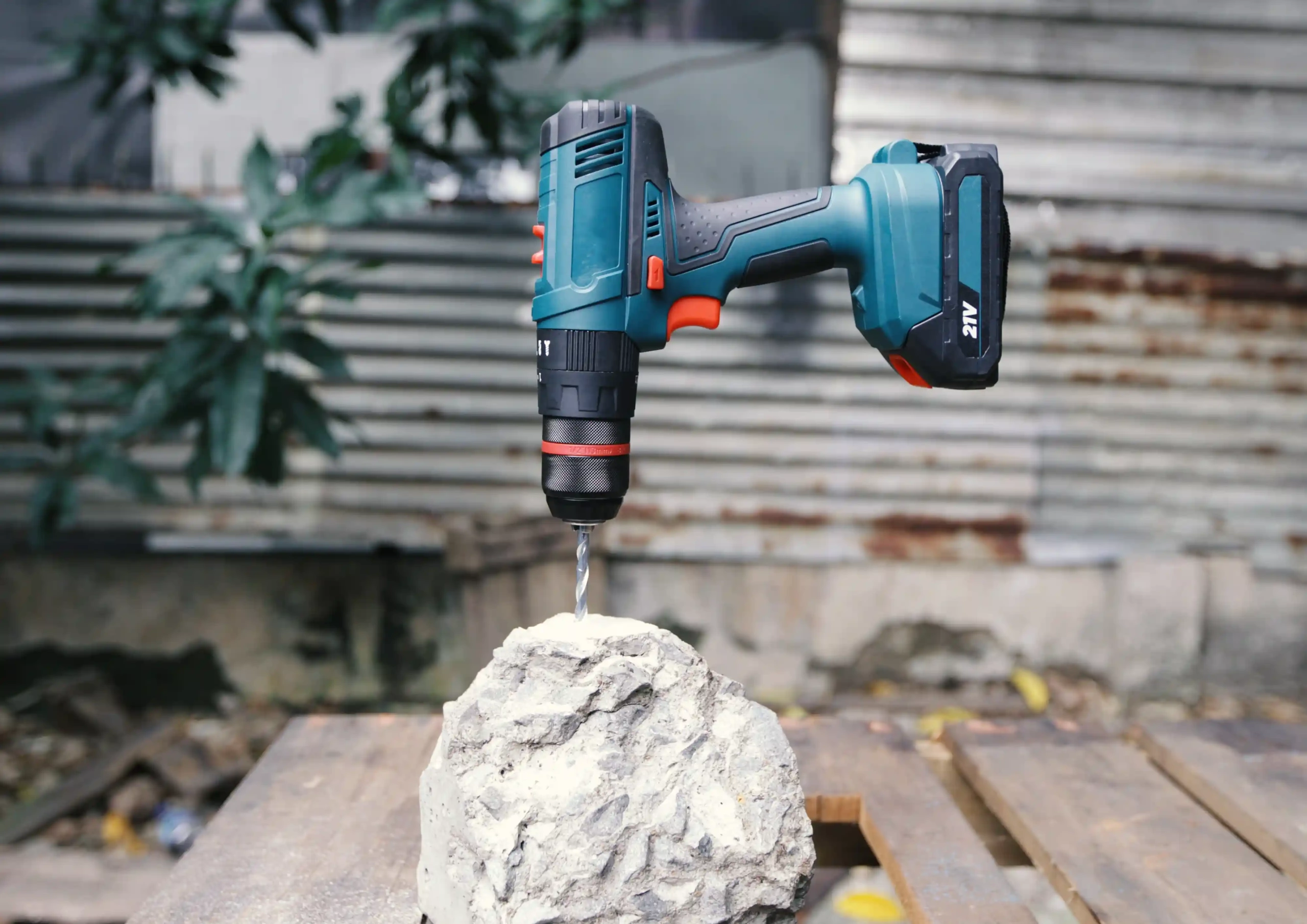 Cordless drill drilling into a rock outdoors