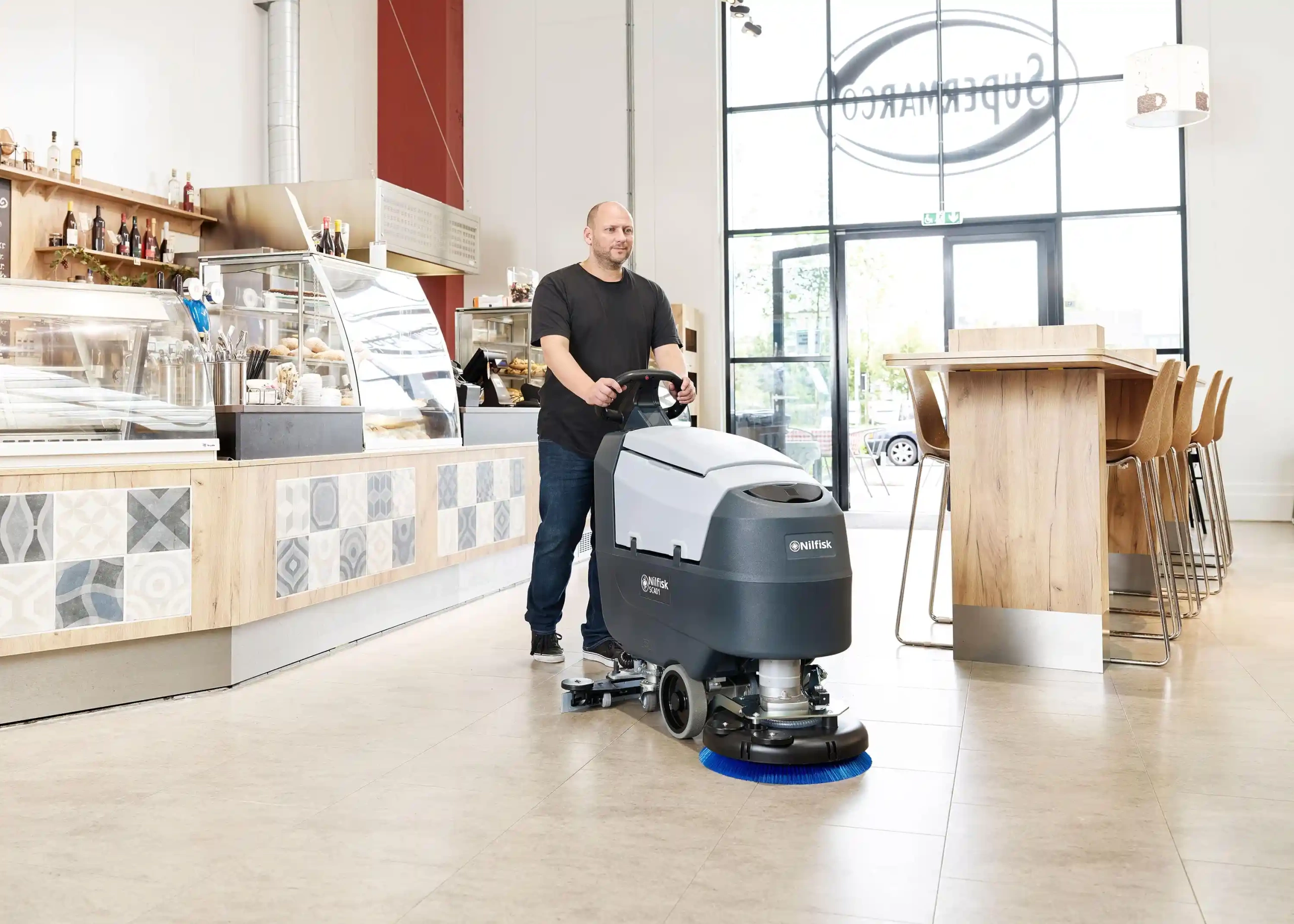 Picture of a man using a Nilfisk industrial vacuum cleaner brand