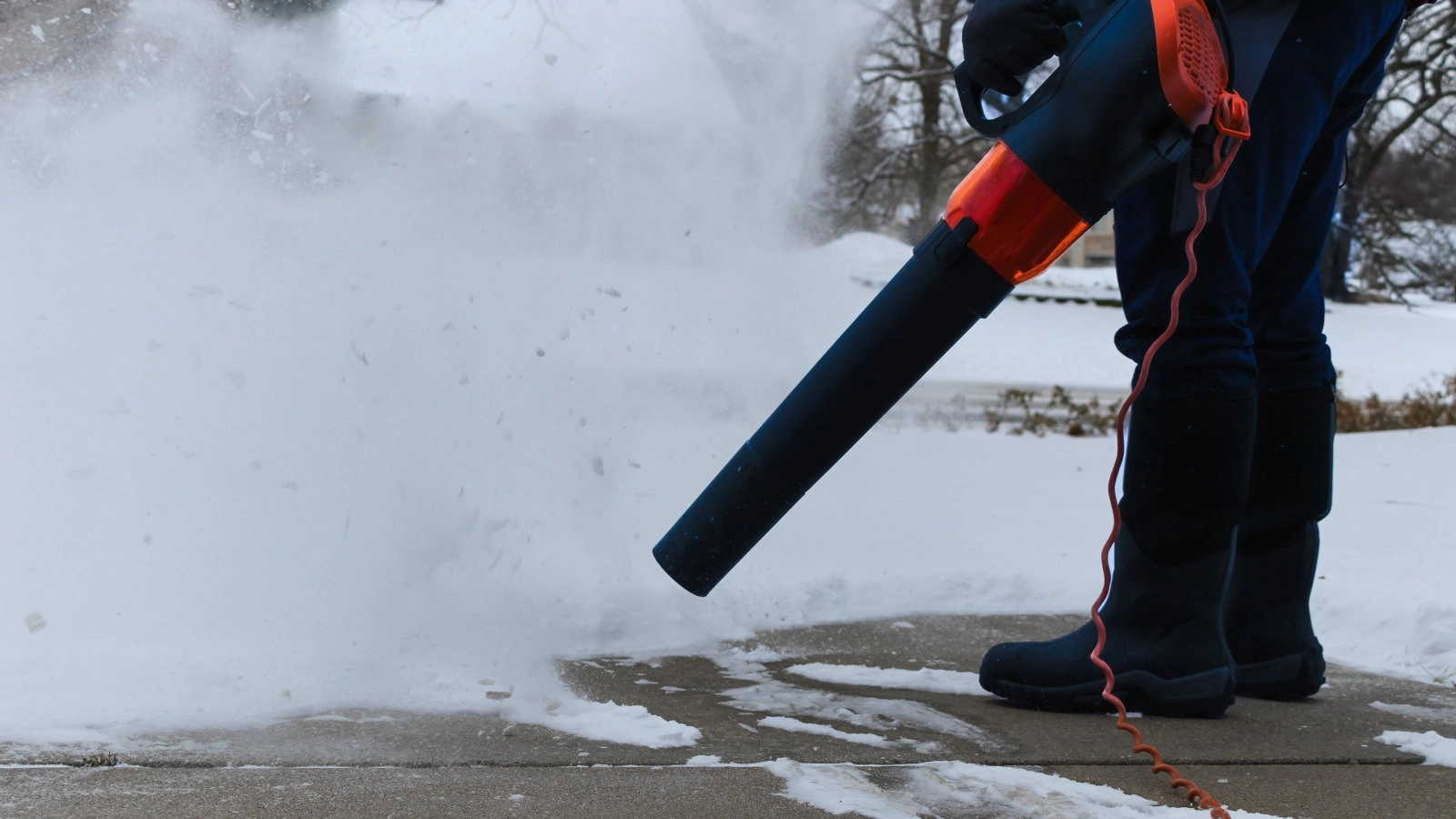 picture of a person using a leaf blower to remove snow