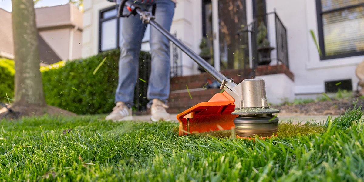 Picture of a person using a cordless string trimmer