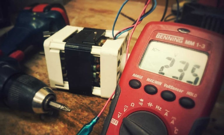 Un operario mide el voltaje de batería de un taladro