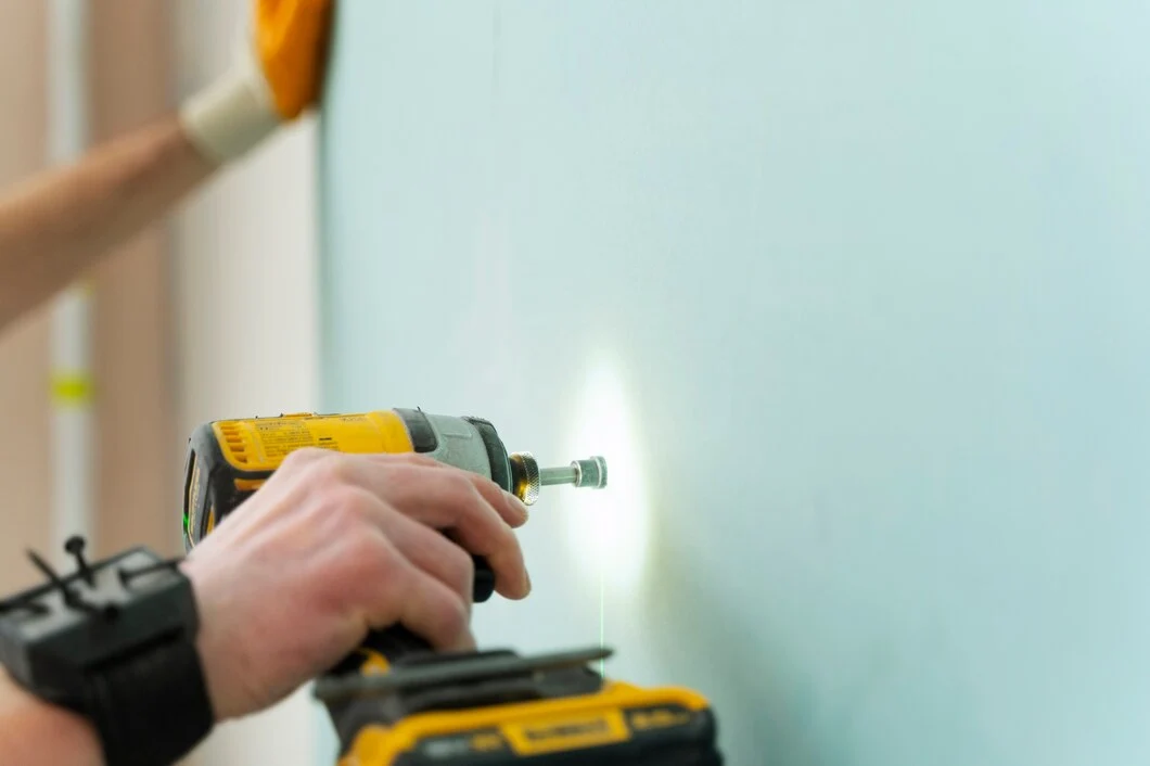 Un hombre trabajando con atornillador inalámbrico una luz LED