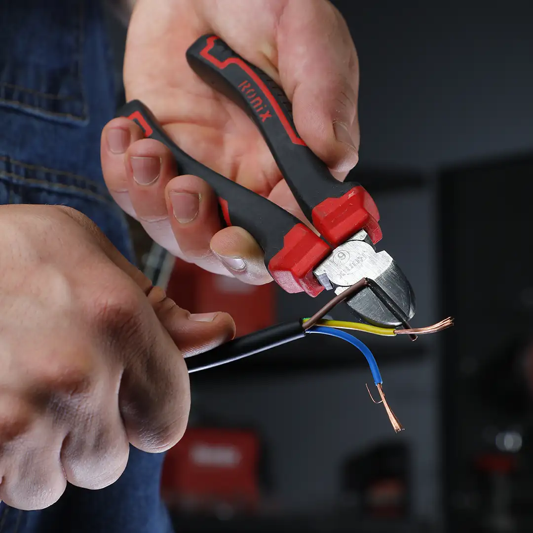 Alicates universales Ronix utilizados para cortar cables en una instalación eléctrica