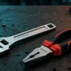 Llave inglesa y alicates Ronix sobre una mesa de trabajo profesional